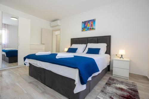 a bedroom with a large bed with blue and white sheets at R&R Residence Podstrana in Podstrana