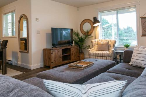 a living room with a couch and a tv at Cozy Renovated Oasis W Private Terrace & Parking in Victoria