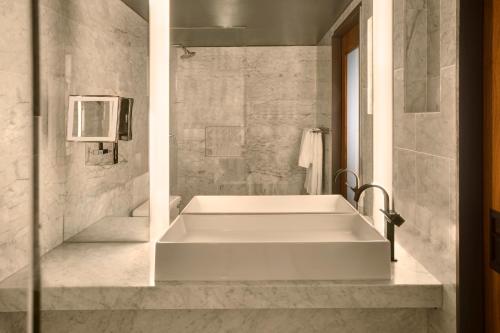 a bathroom with a large tub and a sink at SIXTY Beverly Hills in Los Angeles