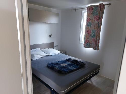a bed in a small room with a window at CARNAC Mobil-Home Camping 4 étoiles in Carnac