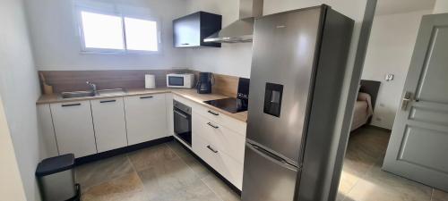 uma cozinha com um frigorífico de aço inoxidável num quarto em Extraordinaire guest house sur la route de Pozzo em Brando