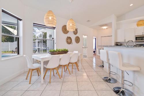 a kitchen and dining room with a white table and chairs at VILLA LAS PALMAS Beautiful Fenced-in Pool Home with Spa- Sleeps 8 in Flagler Beach