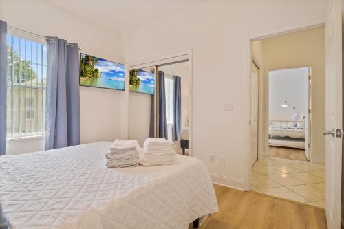 a bedroom with a white bed with towels on it at VILLA LAS PALMAS Beautiful Fenced-in Pool Home with Spa- Sleeps 8 in Flagler Beach