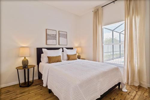 パーム・コーストにあるWHISPERING PALM Newly renovated cozy fenced in pool home - sleeps 8の大きなベッドと窓のある白い寝室