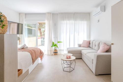 uma sala de estar branca com uma cama e um sofá em OleHolidays 413 Romana Playa Primera línea playa em Marbella