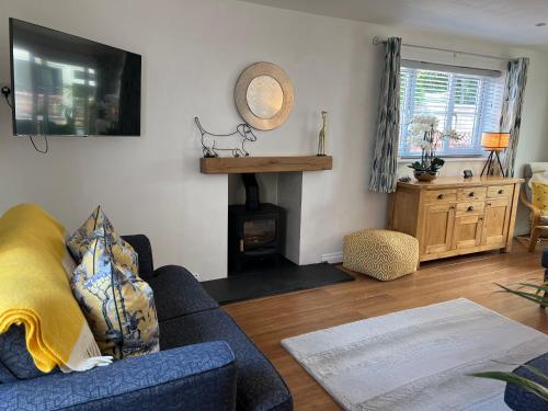 a living room with a blue couch and a fireplace at Monty Cottage, Exmouth Coastal Boutique House in Exmouth