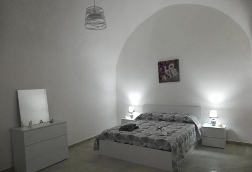 a white bedroom with a bed and two night stands at Maison de Marie in Trani