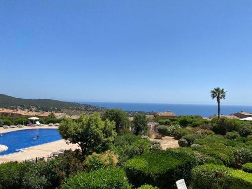 une vue d'un complexe hôtelier avec piscine et l'océan dans l'établissement Appart. vue mer avec piscine - Golfe de St Tropez, aux Issambres