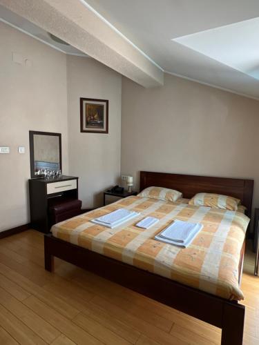 a bedroom with a large bed and a dresser at Hotel Royal in Bijelo Polje