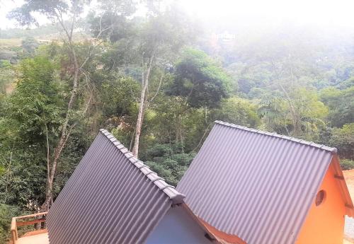 two roofs of a house with trees in the background at QuiCupimNunCria in Miguel Pereira