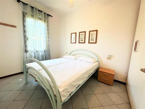 een slaapkamer met een bed en een nachtkastje. bij Villa Giulia in Bibione