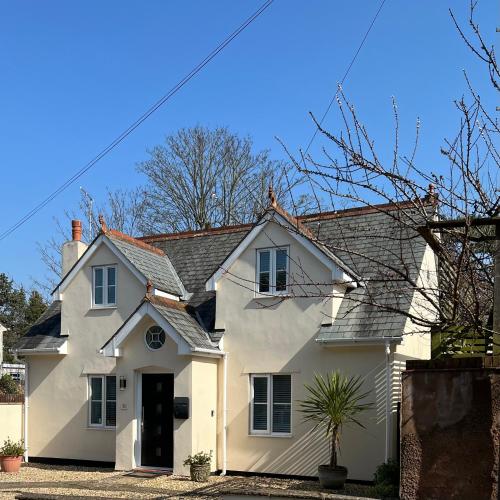 a white house with a black door at Monty Cottage, Exmouth Coastal Boutique House in Exmouth