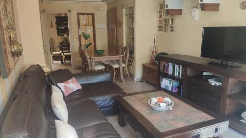 a living room with a leather couch and a coffee table at Apartamento en Torremolinos in Torremolinos