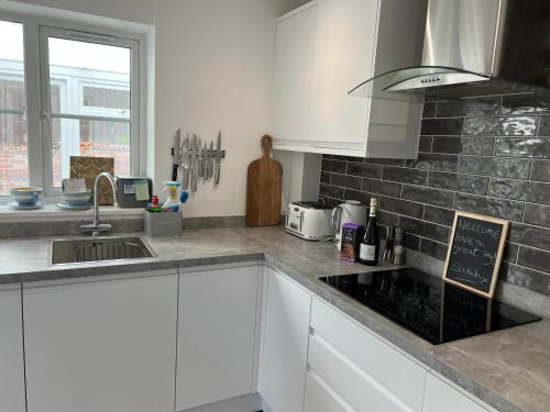 a kitchen with white cabinets and a counter top at Monty Cottage, Exmouth Coastal Boutique House in Exmouth
