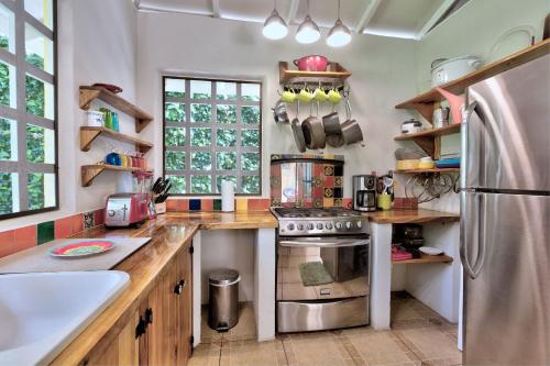 a kitchen with a stainless steel refrigerator and wooden counters at Casa Mariposa 2 BR in Playa Chiquita in Punta Uva