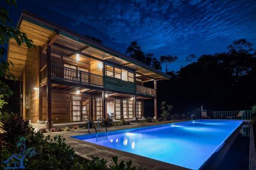 a house with a large swimming pool in front of it at Luxury Villa Panorama Verde Pool House in Punta Uva