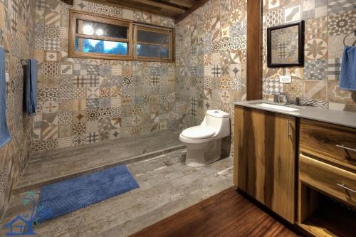 a bathroom with a toilet and a sink and a shower at Luxury Villa Panorama Verde Pool House in Punta Uva