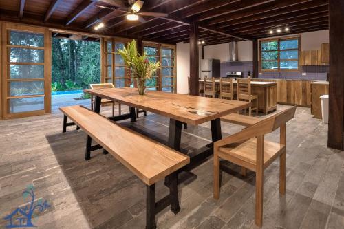 a dining room with wooden tables and benches at Luxury Villa Panorama Verde Pool House in Punta Uva