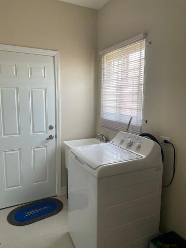 a white washing machine in a bathroom with a window at Aquamarine Resort-style Vacations in Lucea