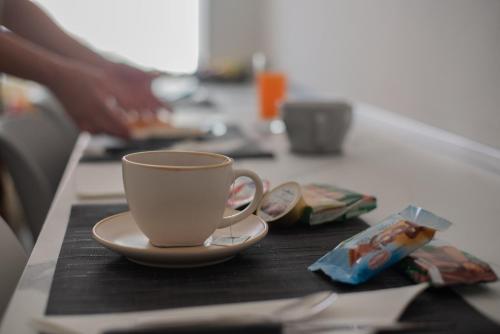 a cup of coffee sitting on a counter with a plate at B&B Cardedu in Cardedu