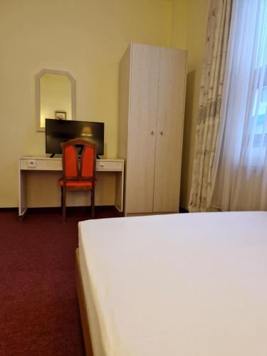 a bedroom with a bed and a desk and a chair at Casa Palace in Timişoara
