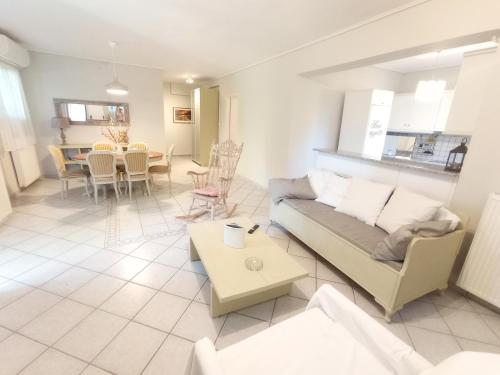 ein Wohnzimmer mit einem Sofa und einem Tisch in der Unterkunft Galini apartment near sea, port and airport in Artemida