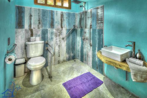 niebieska łazienka z toaletą i umywalką w obiekcie Beachfront Villa Sea Breeze w AC and POOL w mieście Puerto Viejo