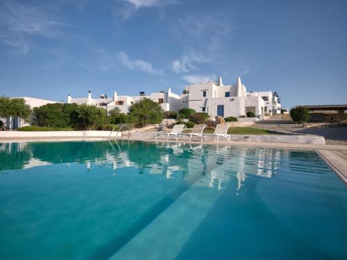 una piscina di fronte a un grande edificio bianco di Leticia Villa with pool with amazing sea views, Paros a Márpissa