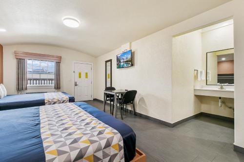 a hotel room with two beds and a table at Lighthouse Inn in South Padre Island