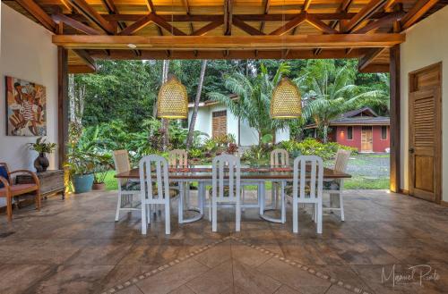 a dining room table and chairs on a patio at Luxury Villa Macaw Pool House with FiberOp and Oceanviews in Punta Uva