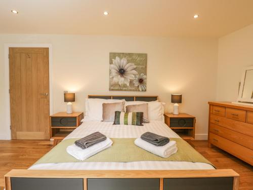 um quarto com uma cama grande e 2 mesas de cabeceira em The Old Stables em Gillingham