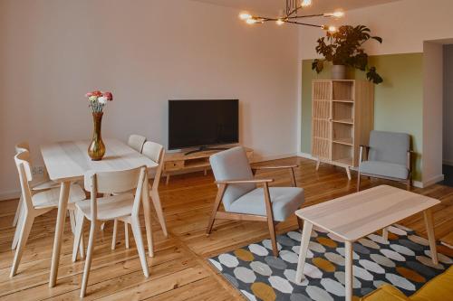 a living room with a table and chairs and a television at Apartament D16 in Pińczów