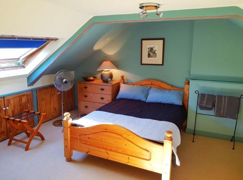 a bedroom with a wooden bed in a attic at Alma House Bed and Breakfast in Newbury