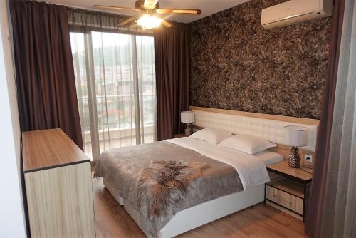a bedroom with a bed and a large window at Millennium Apart Complex in Sveti Vlas