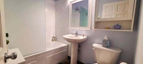 a white bathroom with a sink and a toilet at The White House in Sechelt