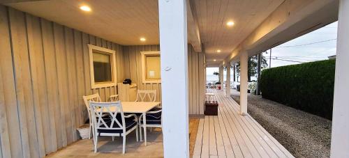 a table and chairs on a porch of a house at The White House in Sechelt