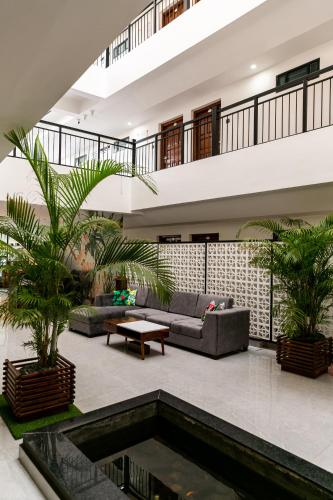 a living room with a couch and a swimming pool at Aloha Holiday Resort in Baga
