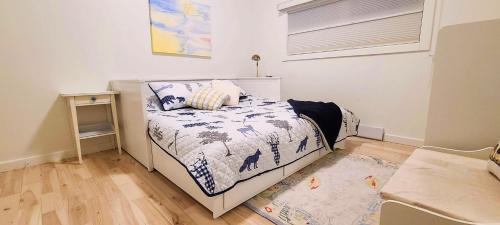 a small bedroom with a bed and a rug at The White House in Sechelt
