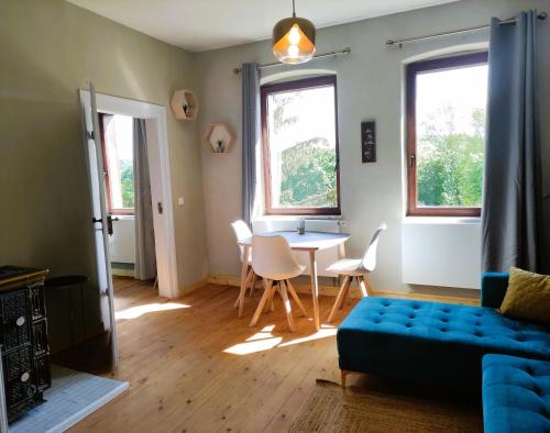 ワイマールにあるNostalgie Apartment Weimarのリビングルーム(青いソファ、テーブル付)