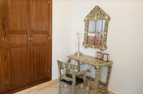 a dressing table with a mirror and a chair at La Claire Fontaine in Marrakech