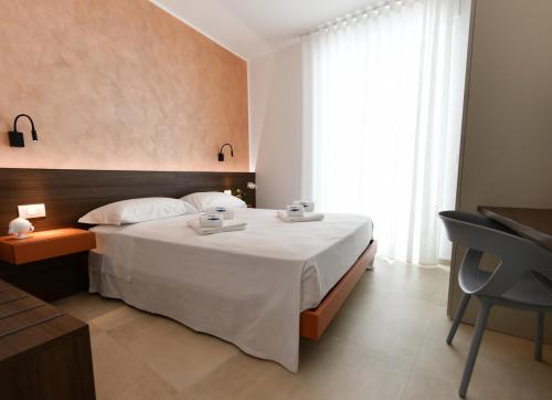 a bedroom with a white bed and a table and a chair at Vilu Suite Centro in Polignano a Mare