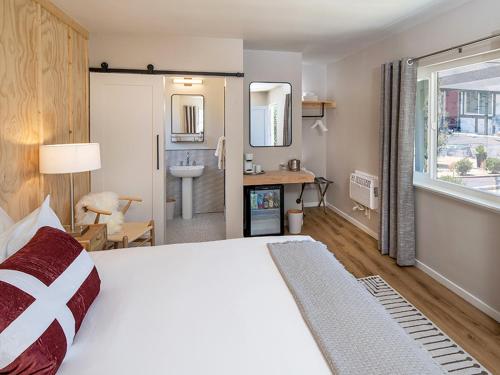 a bedroom with a large bed and a bathroom at Hotel Hygge in Buellton