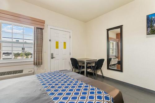 a bedroom with a bed and a table and a window at Lighthouse Inn in South Padre Island