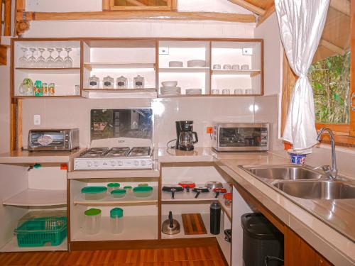 a small kitchen with a sink and a stove at La Casa en el Aire Mindo, 4 Dormitorios in Mindo