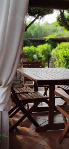 - une table de pique-nique en bois et des bancs sur une terrasse dans l'établissement Sardinia82 Sunsetplace, à Palau