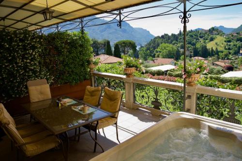 uma banheira de hidromassagem numa varanda com uma mesa e cadeiras em Villa Vitali - Bellagio em Bellagio