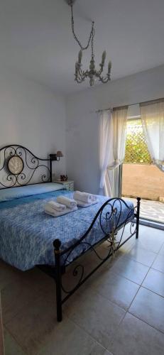 a bedroom with a bed with a blue blanket and a window at Sardinia82 Sunsetplace in Palau