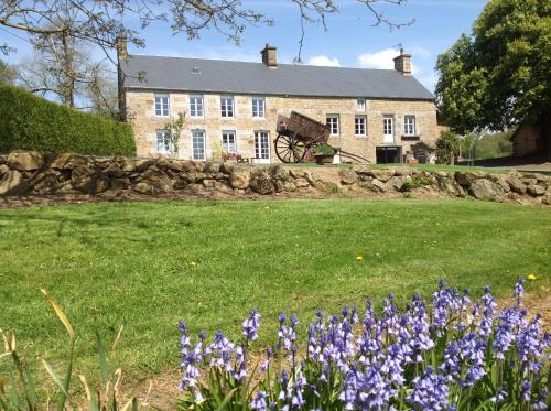 a house with purple flowers in front of it at LES ROCAILLES in La Forêt-Auvray