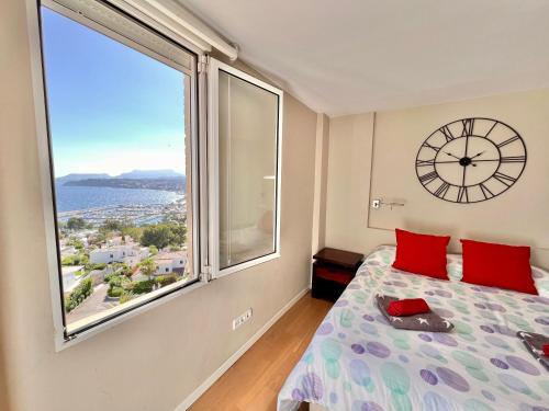a bedroom with a large window and a clock on the wall at Xaloc Moraira in Moraira