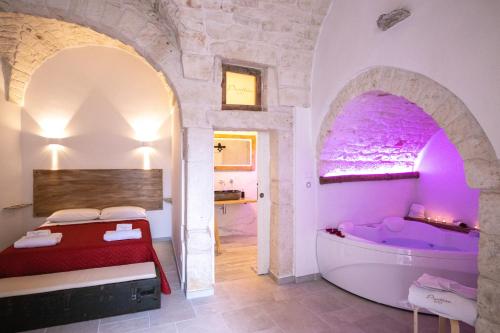 1 dormitorio con bañera y 1 cama en una habitación en Pasithèa Suite, en Ceglie Messapica